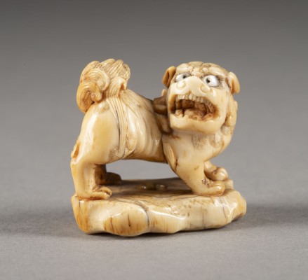 Auction <br>EIN GESCHNITZTES NETSUKE EINES SHISHI AUS ELFENBEIN