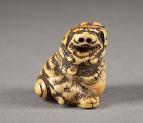 Auktion <br>EIN GESCHNITZTES NETSUKE EINES SHISHI AUS ELFENBEIN