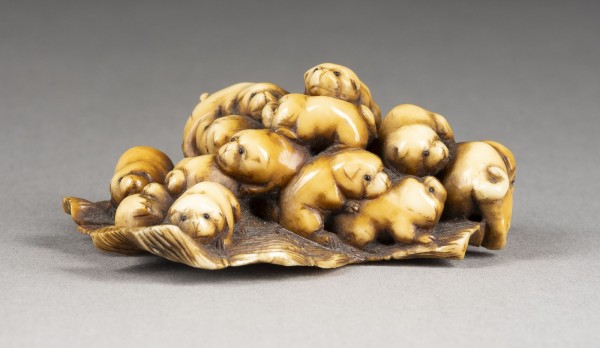 Auction 143<br>EIN GESCHNITZTES NETSUKE EINER GRUPPE VON WELPEN AUS ELFENBEIN