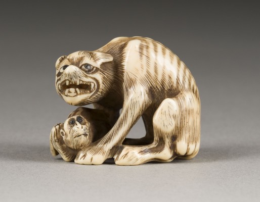 Auktion 148<br>EIN NETSUKE VON EINEM ABGEMAGERTEN WOLF MIT EINEM AFFEN AUS ELFENBEIN