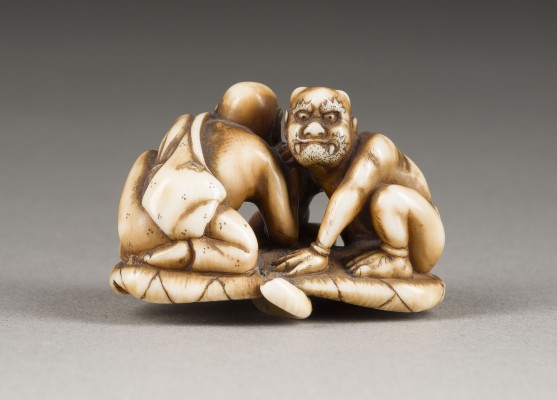 Auction 148<br>EIN NETSUKE VON RAKAN UND ONI IM ARMDRÜCKEN AUS ELFENBEIN