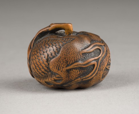Auktion 148<br>EIN NETSUKE VON EINEM DRACHEN IN EINEM MIKAN (TANGERINE) AUS HOLZ