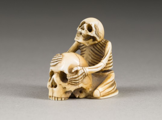 Auktion 148<br>EIN GESCHNITZTES NETSUKE EINES SKELETTS MIT EINEM SCHÄDEL AUS ELFENBEIN