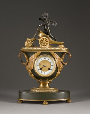 Auktion 155<br>FEINE TISCHUHR IM EMPIRE-STIL MIT AMOR AUF WAGEN