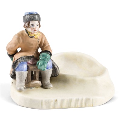 Auktion 161<br>FIGÜRLICHER ASCHENBECHER MIT EINEM JUNGEN AUF SCHLITTEN